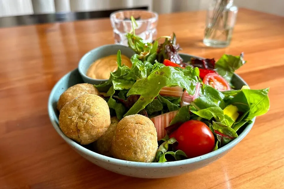 Bunte Bowl mit Salat, Tomate und Kartoffelküchle